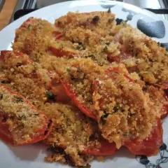 Pomodori gratinati al forno, un piatto saporito con pangrattato croccante e erbe aromatiche.
