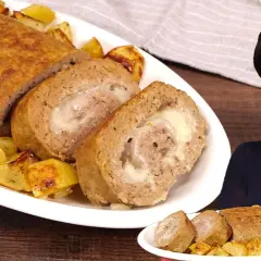 Un delizioso polpettone al forno, ripieno di formaggio filante, servito con patate arrosto.