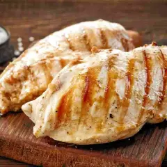Petto di pollo grigliato, perfetti secondi di carne da preparare in anticipo. Un contorno di sale completa l'immagine.