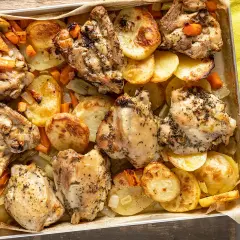 Sovracosce di pollo dorate al forno con patate, carote e sedano, un piatto succulento e profumato.
