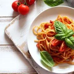 Spaghetti conditi con sugo di pomodoro fresco e basilico, guarniti con pomodorini. Un piatto semplice e gustoso.