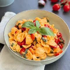 Orecchiette alla crudaiola con pomodorini freschi, basilico e un tocco di formaggio, un piatto estivo da gustare.