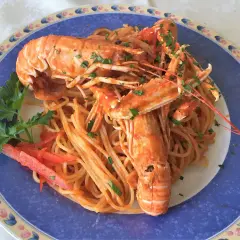 Linguine alla busara con scampi succulenti, un piatto di mare che profuma di festa e sapori autentici.
