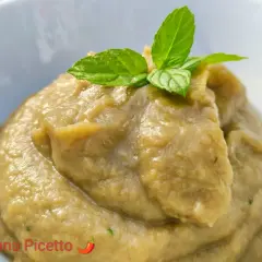 Un cremoso pesto di melanzane, guarnito con foglie di menta fresca, pronto per essere gustato.