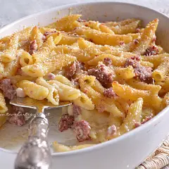 Un invitante piatto di pasta al forno con salsiccia, gratinata e dorata, pronta per essere gustata.