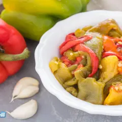 Peperoni arrostiti al forno ventilato o statico, conditi con aglio, pronti per essere gustati.