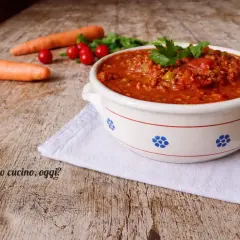Un invitante sugo con macinato veloce, pronto per condire la pasta. Carote e pomodorini freschi completano la scena.