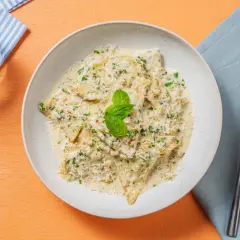 Ravioli cremosi con pesto di noci, parmigiano e basilico fresco.