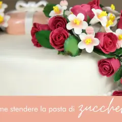 Torta decorata con rose e fiori in pasta di zucchero, un'elegante composizione per ogni occasione.