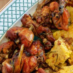 Un saporito coniglio in padella, dorato e aromatico, servito con polenta morbida e rosmarino.