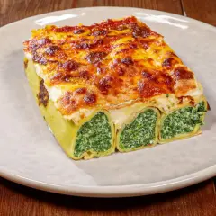 Crespelle alla fiorentina, rotoli di pasta ripieni di spinaci e ricotta, gratinati al forno con formaggio fuso.