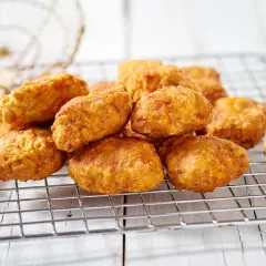 Nuggets fatti in casa dorati e croccanti, appena scolati su una griglia.