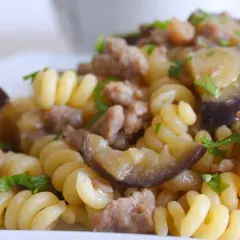 Fusilli con salsiccia e melanzane, un piatto gustoso e colorato, pronto per essere assaporato.