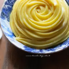 Una spirale perfetta di crema al latte, liscia e invitante, in una ciotola decorata.