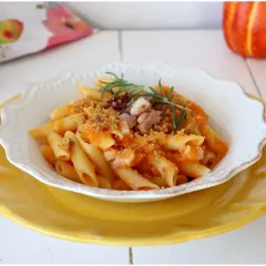 Penne con crema di zucca, pancetta croccante e rosmarino. Un piatto autunnale che celebra i sapori della terra.