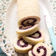 Un invitante rotolo alla marmellata, con la sua soffice pasta e il ripieno colorato, pronto per essere gustato.