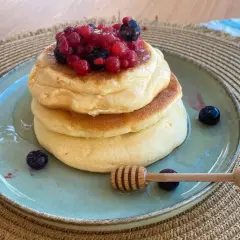 Pancake con albumi soffici, guarniti con frutti di bosco e miele. Un dolce leggero e goloso.