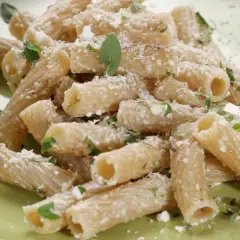 Maccheroni alla pastora conditi con formaggio grattugiato e erbe aromatiche fresche, un piatto semplice e gustoso.