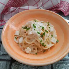 Spaghetti cremosi con cubetti di mozzarella di bufala e prezzemolo fresco, un piatto semplice e delizioso.