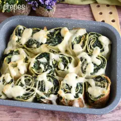 Girelle di crepes con spinaci e formaggio filante, un piatto invitante e gustoso.