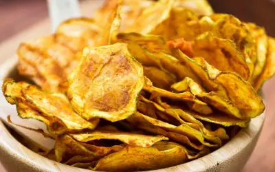 Croccanti zucchine al forno, dorate e saporite, servite in una ciotola di legno.