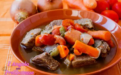 Un invitante brodo di carne con pezzi succulenti, carote, pomodori e cipolle. Un piatto caldo e confortante, perfetto per le giornate fredde.