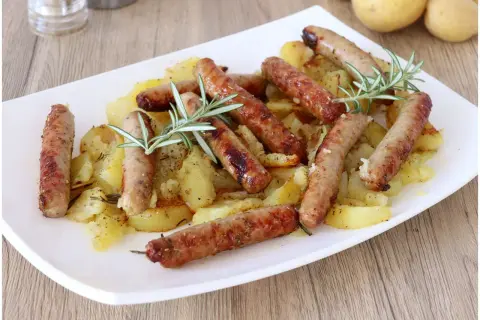 Salsicce e patate al forno, un piatto gustoso e profumato, con rosmarino fresco.