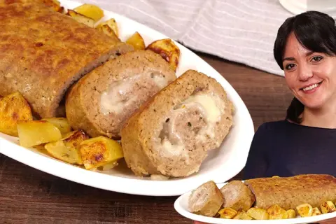 Un delizioso polpettone al forno, ripieno di formaggio filante, servito con patate arrosto.