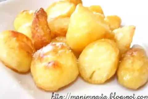 Un mucchio invitante di patate al forno dorate e croccanti, cosparse di un leggero velo di sale.
