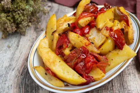 Patate e peperoni al forno, un contorno saporito e colorato, pronto per essere gustato.