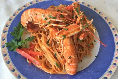 Linguine alla busara con scampi succulenti, un piatto di mare che profuma di festa e sapori autentici.