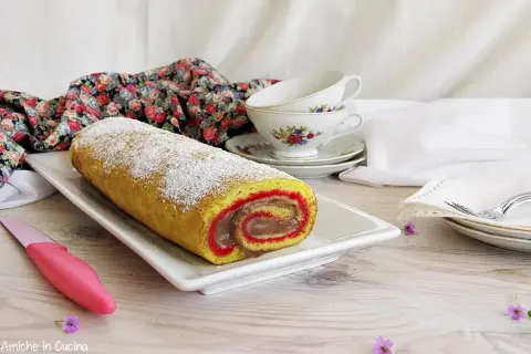 Rotolo dolce spolverato di zucchero a velo, un vero salame del re, con ripieno cremoso e bordi rossi.