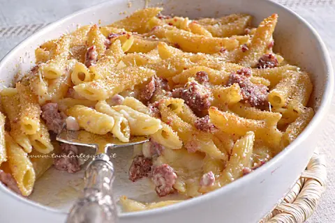 Un invitante piatto di pasta al forno con salsiccia, gratinata e dorata, pronta per essere gustata.