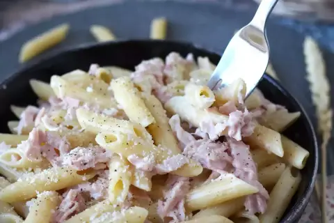 Penne cremose con prosciutto cotto e parmigiano, un piatto di pasta panna e prosciutto che invita a un assaggio.