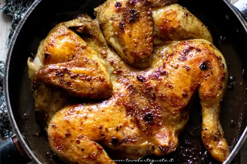 Pollo alla diavola succulento e dorato, cotto in padella con spezie piccanti.