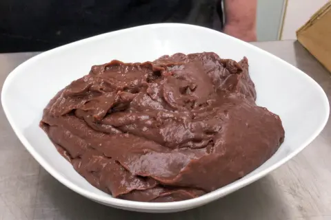 Una ciotola bianca piena di deliziosa crema al cioccolato, pronta per essere gustata.