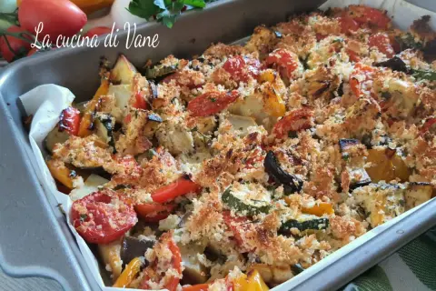 Verdure gratinate al forno, un tripudio di colori e sapori con zucchine, peperoni, melanzane e pomodorini, ricoperte da pangrattato croccante.