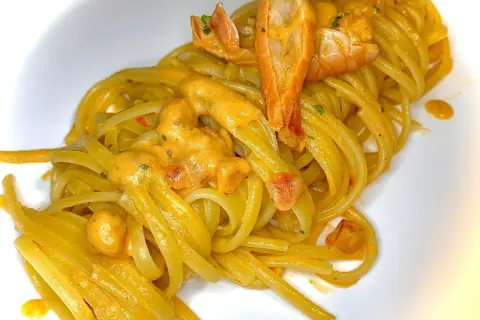 Linguine cremose con un saporito sugo con scampi surgelati, guarnite con pezzi di scampi succulenti.