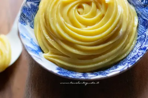 Una spirale perfetta di crema al latte, liscia e invitante, in una ciotola decorata.