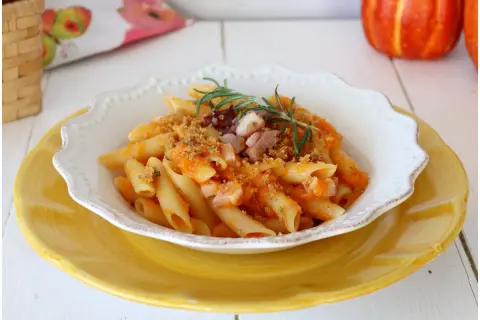 Penne con crema di zucca, pancetta croccante e rosmarino. Un piatto autunnale che celebra i sapori della terra.