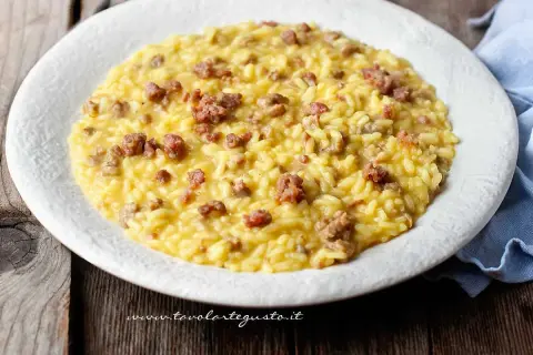 Un cremoso risotto con salsiccia, servito su un piatto bianco, pronto per essere gustato.
