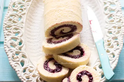 Un invitante rotolo alla marmellata, con la sua soffice pasta e il ripieno colorato, pronto per essere gustato.