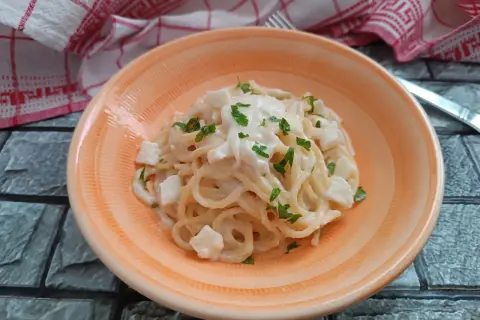 Spaghetti cremosi con cubetti di mozzarella di bufala e prezzemolo fresco, un piatto semplice e delizioso.