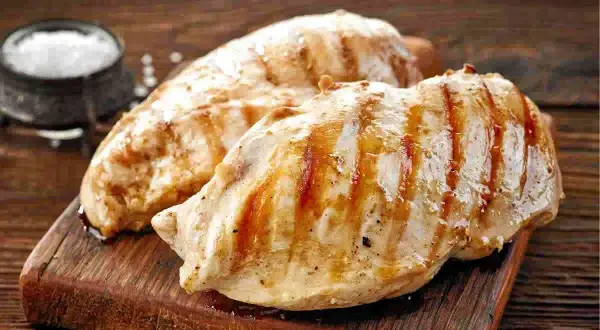 Petto di pollo grigliato, perfetti secondi di carne da preparare in anticipo. Un contorno di sale completa l'immagine.