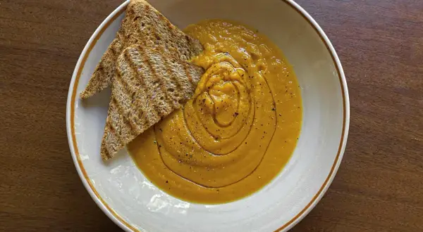 Vellutata di zucca cremosa, guarnita con pepe nero e accompagnata da crostini integrali tostati. Un comfort food perfetto.