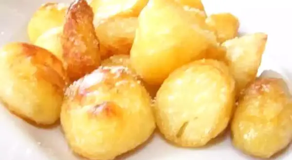 Un mucchio invitante di patate al forno dorate e croccanti, cosparse di un leggero velo di sale.