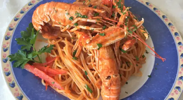 Linguine alla busara con scampi succulenti, un piatto di mare che profuma di festa e sapori autentici.