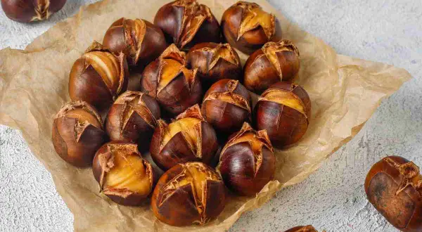 Castagne perfette cotte in friggitrice ad aria, con la buccia aperta che rivela il loro interno dorato e invitante.