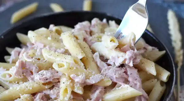 Penne cremose con prosciutto cotto e parmigiano, un piatto di pasta panna e prosciutto che invita a un assaggio.