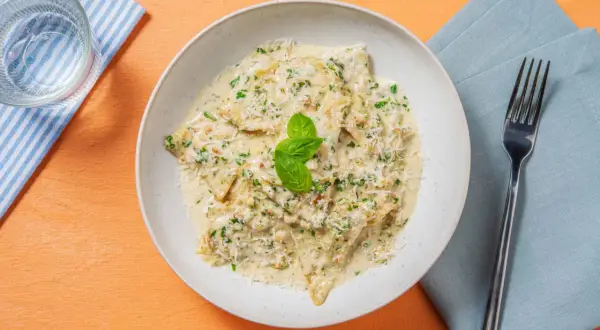 Ravioli cremosi con pesto di noci, parmigiano e basilico fresco.